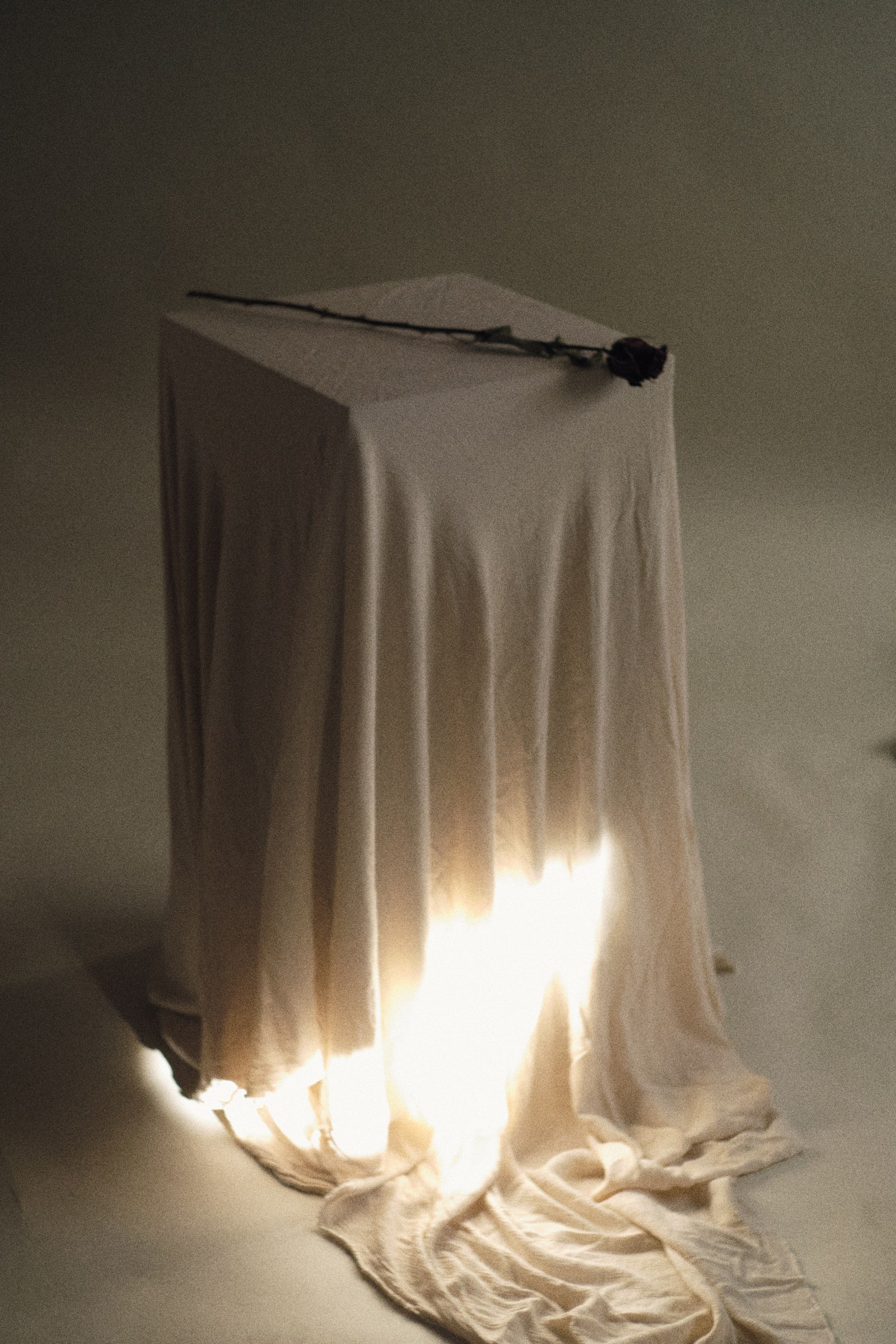 Sunlight falling across a draped pedestal