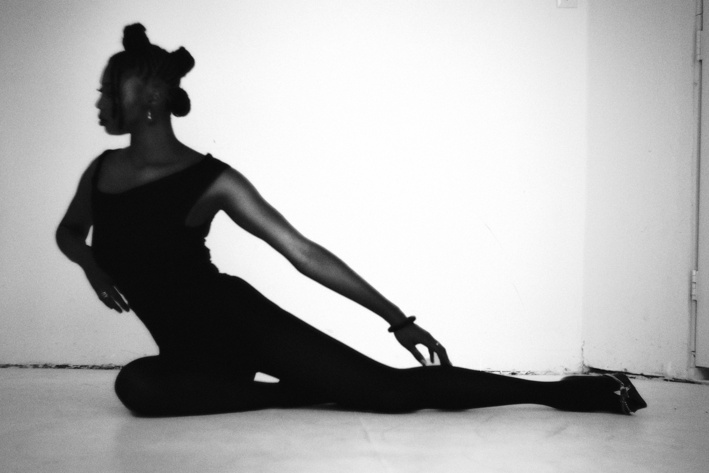 Seated black-dress editorial on a studio floor
