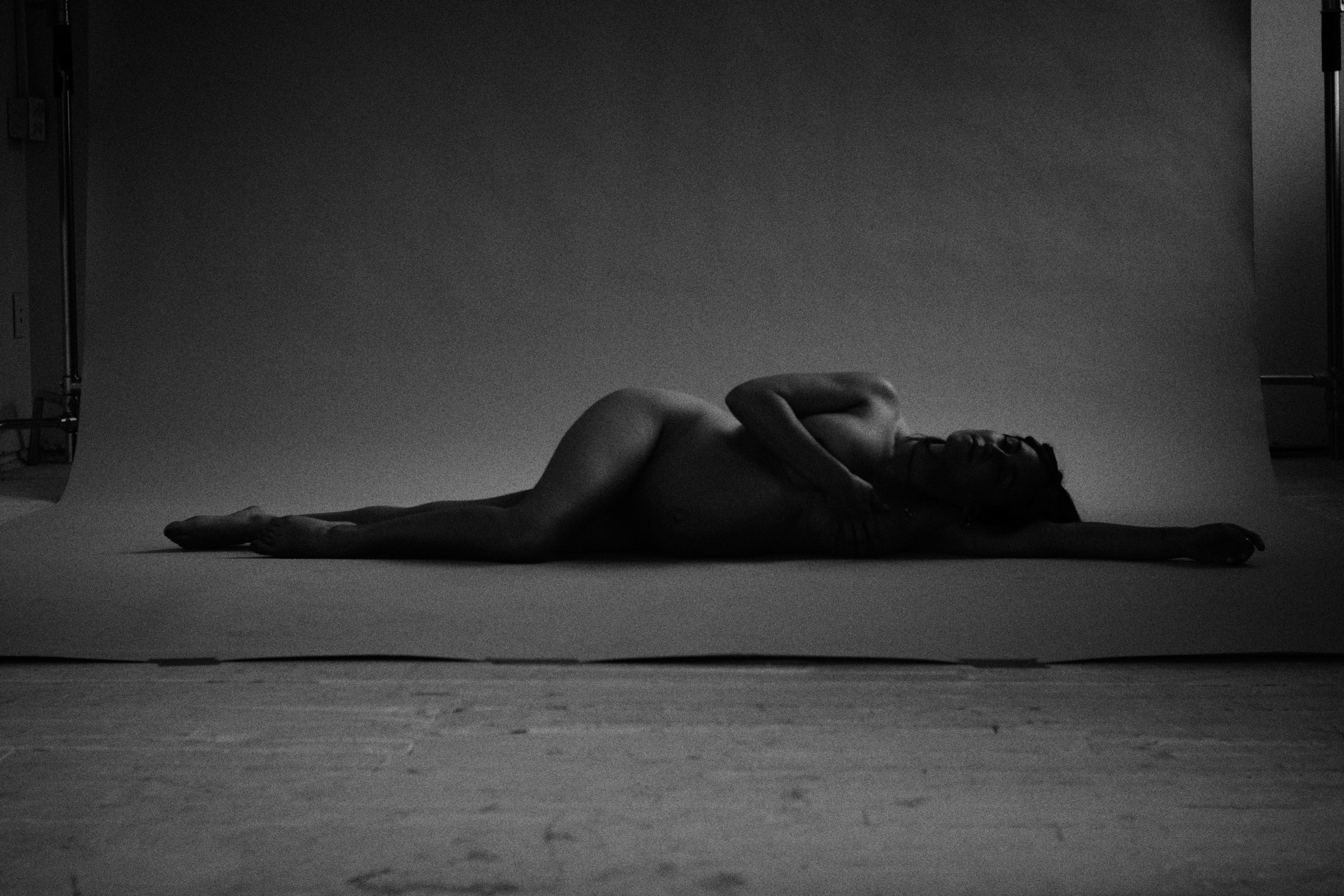 Reclining figure on a dark studio floor