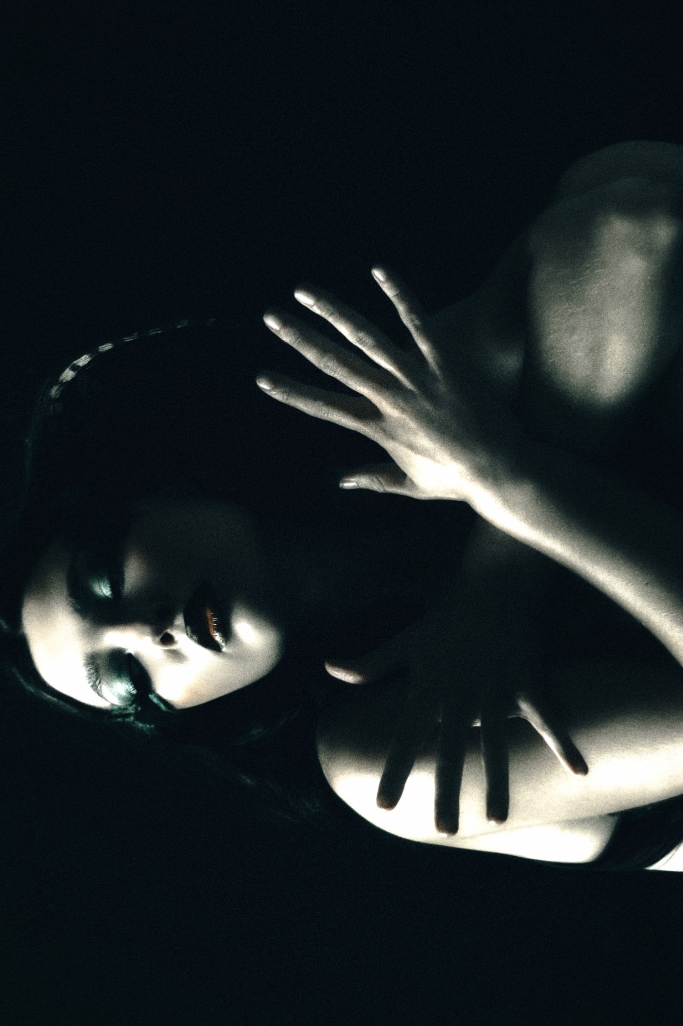 Portrait with hands catching a narrow beam of light