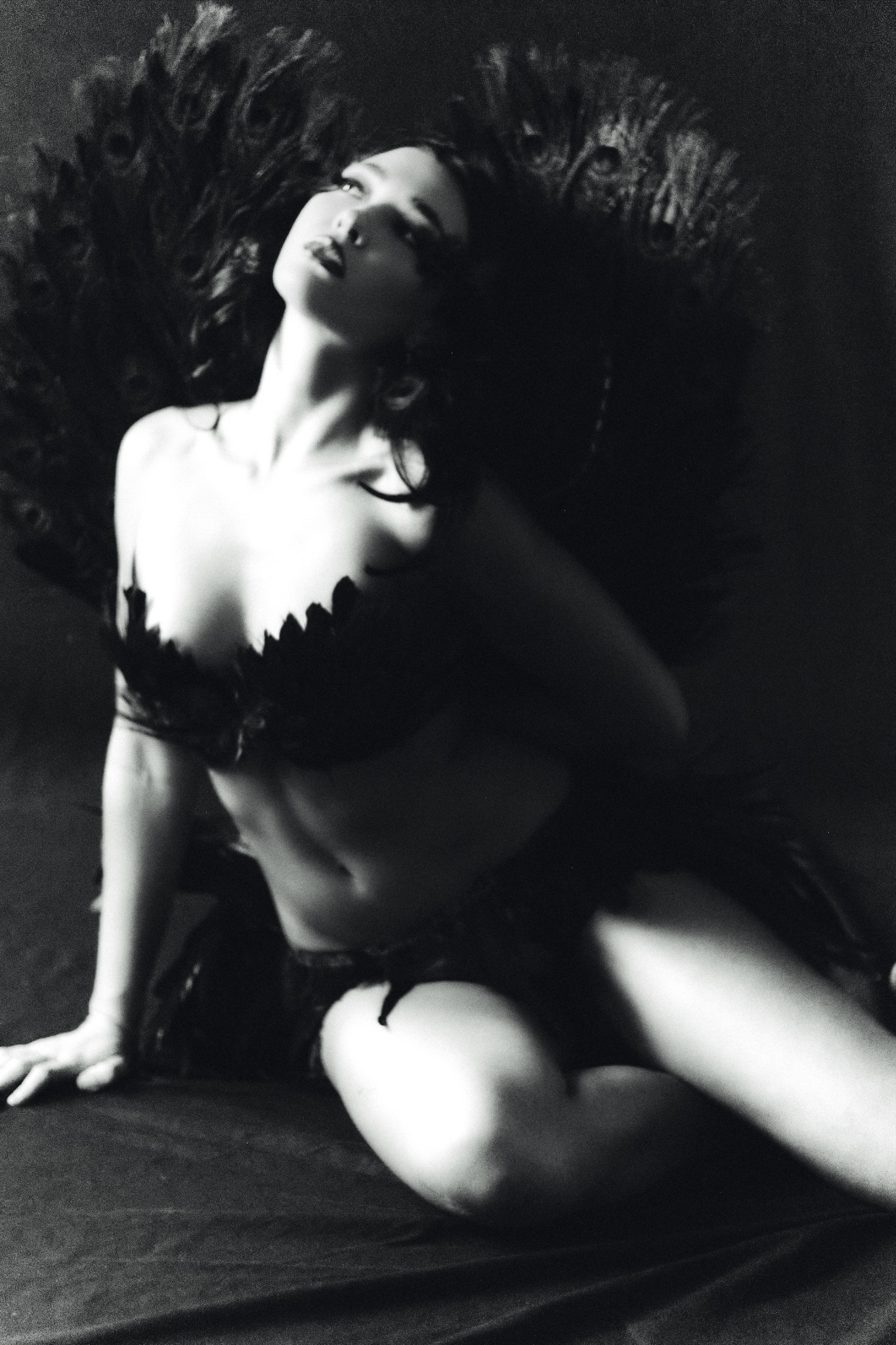 Studio portrait surrounded by dark feathers