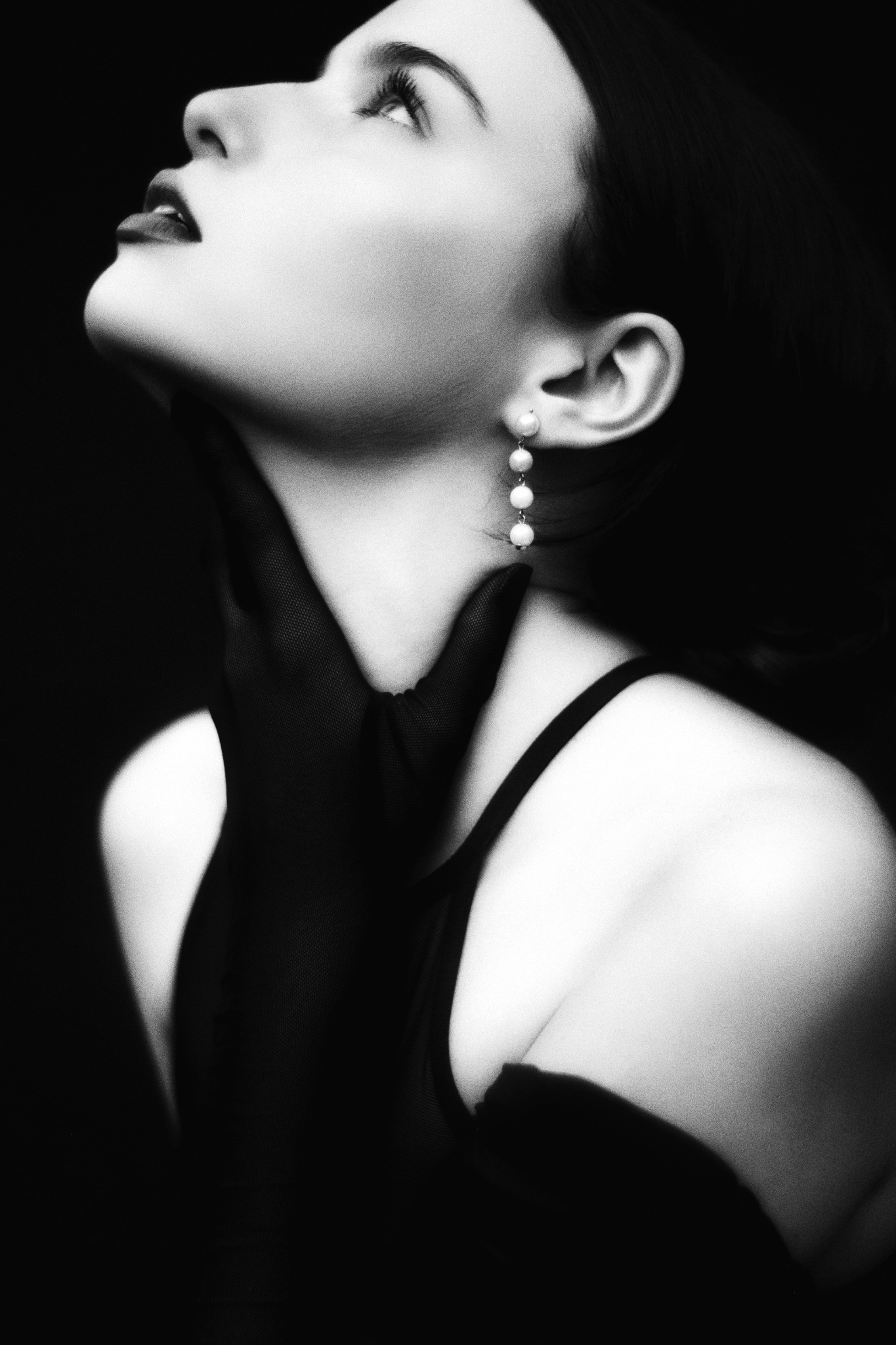 Upward-looking portrait with pearl earrings