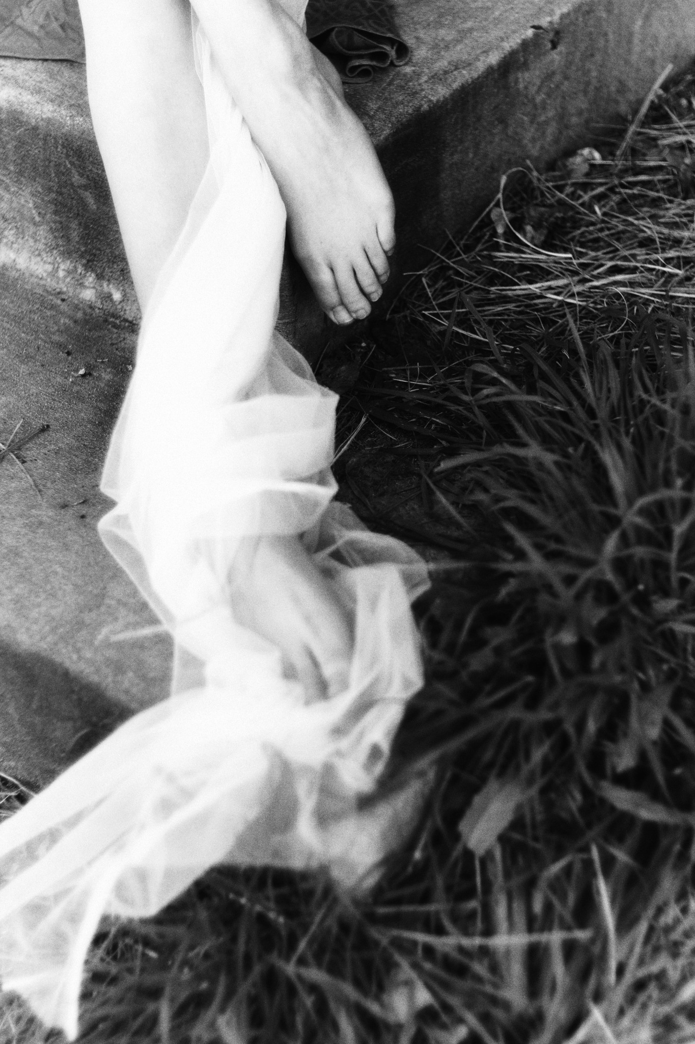Draped fabric and a hand in the grass
