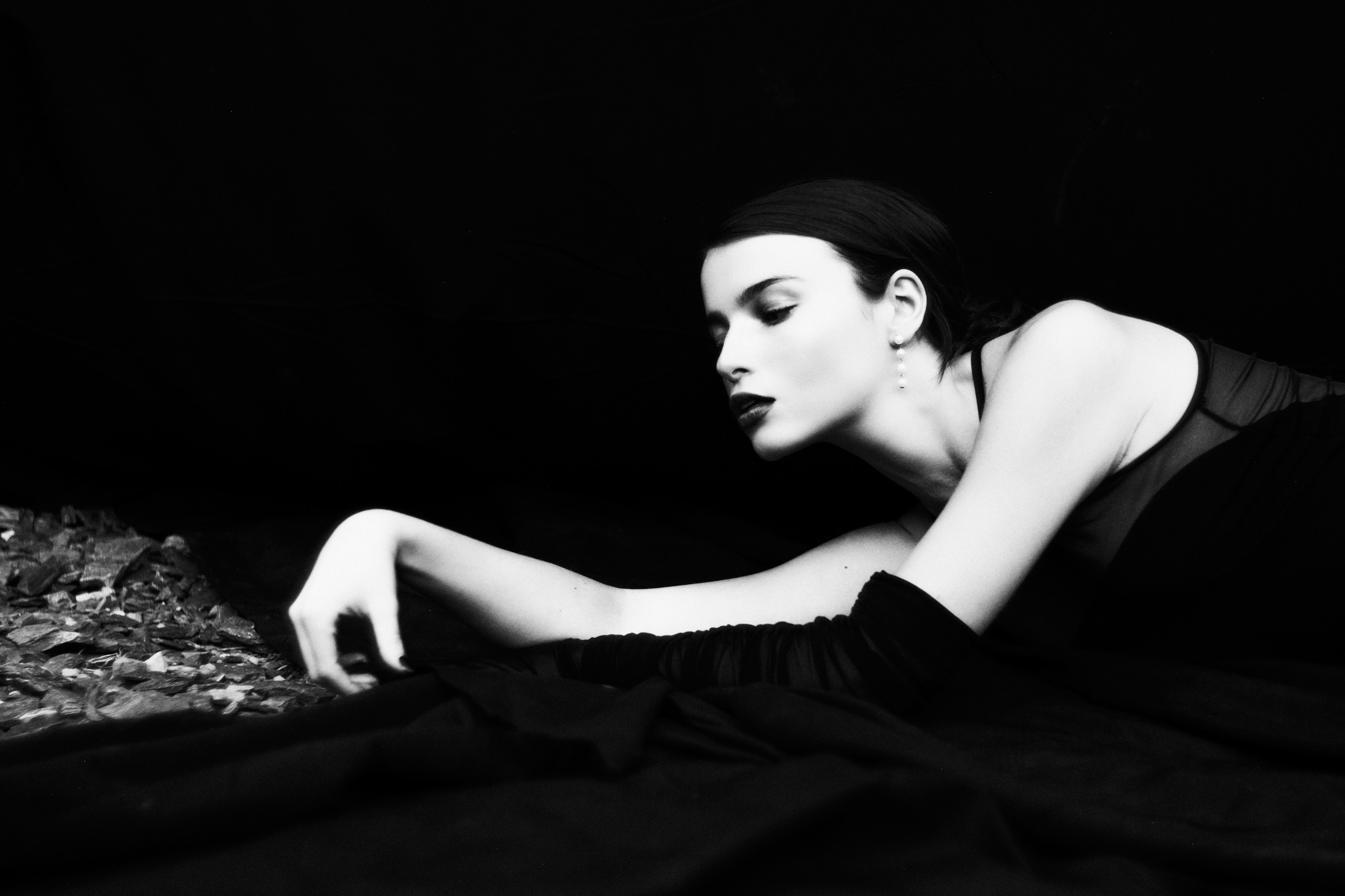 Reclining monochrome portrait with an extended gloved arm
