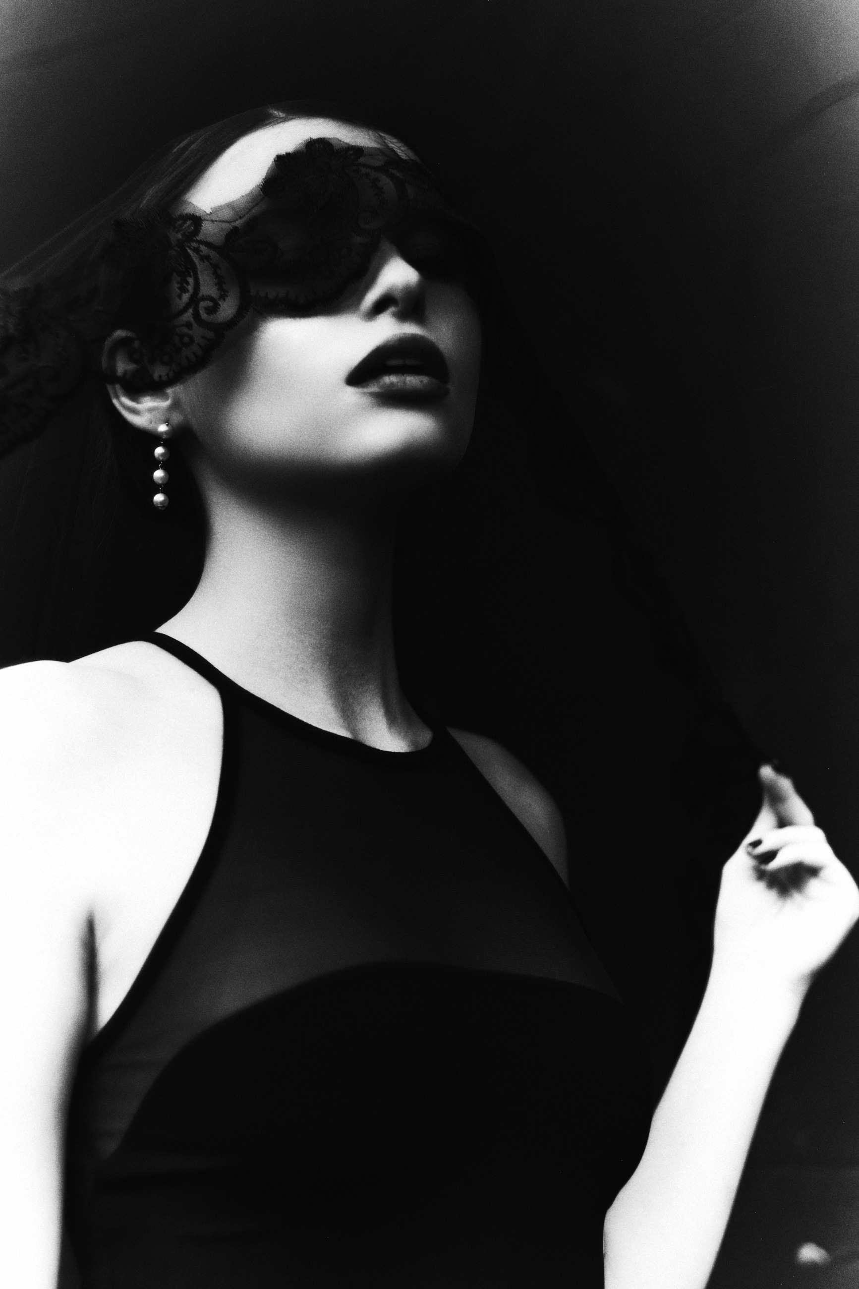 Close monochrome portrait behind a lace blindfold